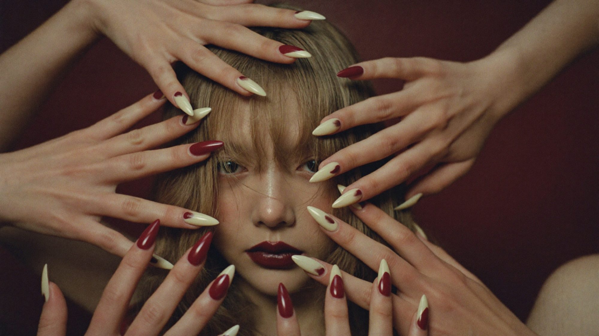Hands with burgundy and cream almond nails